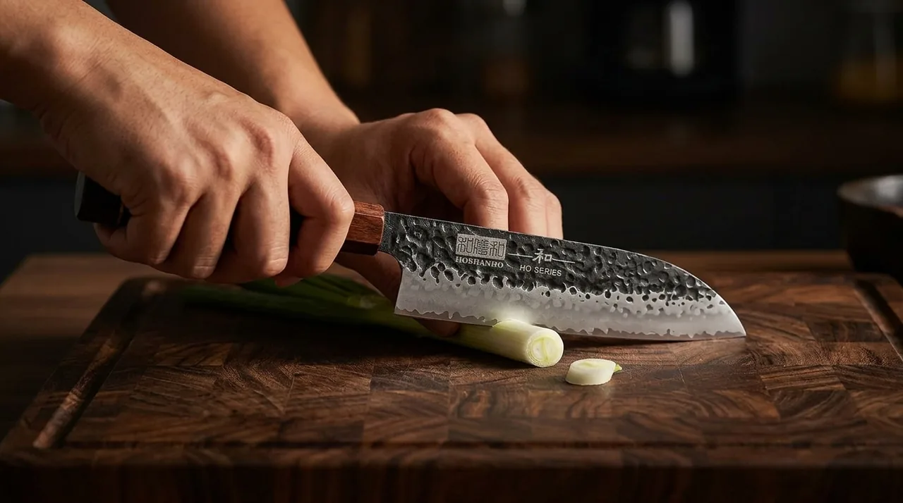 El HOSHANHO Santoku VG-10 cortando verdura sobre tabla de madera